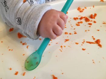 Cropped hand of baby having food