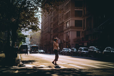 Man on street amidst buildings in city