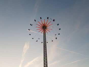 Low angle view of chain swing ride against sky