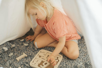 Girl solving wooden puzzles