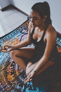 High angle view of young woman doing on carpet at home