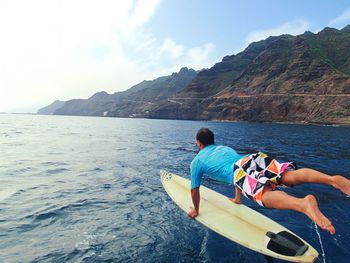 Rear view of man surfing in sea