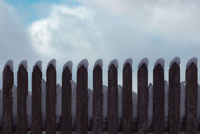 Low angle view of fence against sky during foggy weather