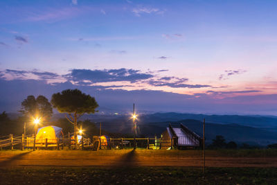 Scenic view of illuminated field against sky during sunset