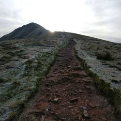 Surface level of barren landscape against sky