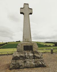 Cross on cemetery against sky