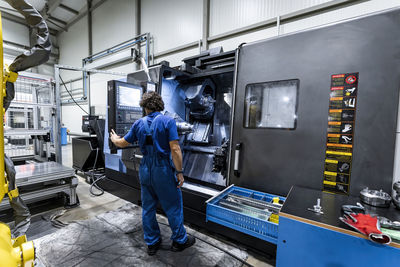 Technician operating cnc machinery in metal industry