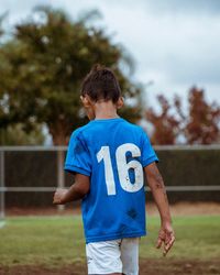 Rear view of man standing on soccer field