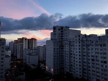 Buildings in city against sky at sunset