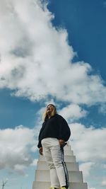 Low angle view of woman standing against sky