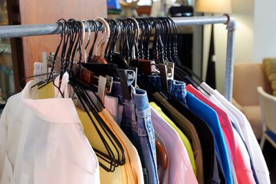 Colorful clothes hanging on rack for sale at store