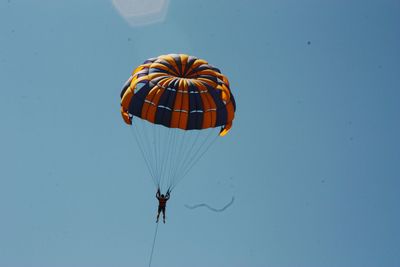 Low angle view of person paragliding against clear sky