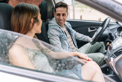 Side view of friends traveling in car