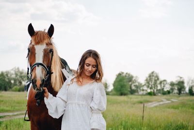 Young woman with horse on field