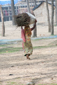 Rear view of woman walking on field