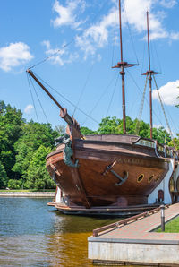 Sailboat moored on shore against sky