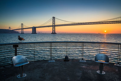 Bay bridge against clear sky at sunrise