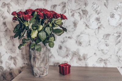 The concept of the holiday. gift in red box and bouquet of roses