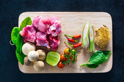 High angle view of raw vegetables along with meat on cutting board