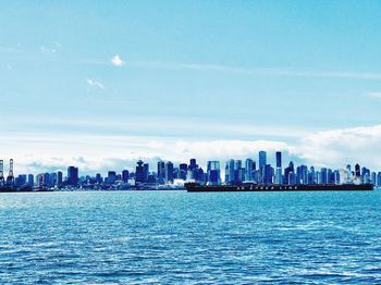 Sea by buildings against sky in city