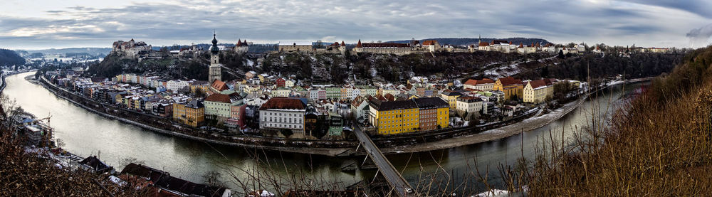 Panoramic view of boats moored in city against sky