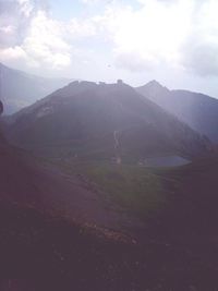 Scenic view of mountains against cloudy sky