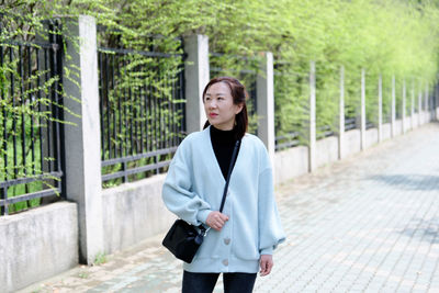 Woman standing on footpath