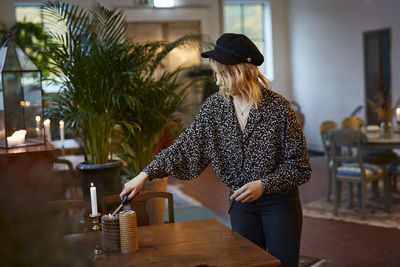 Woman igniting candles in cafe