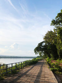 Footpath by mekong river against sky