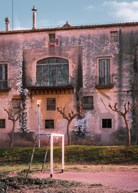 Old building by street against sky