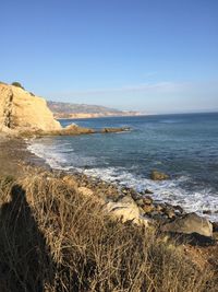 Scenic view of beach against clear blue sky