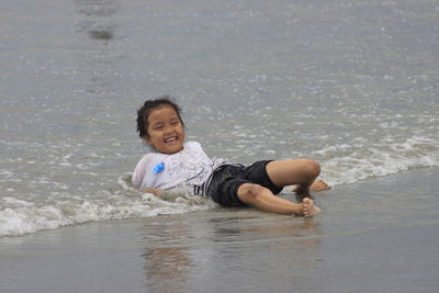 Portrait of young woman playing in the beach.