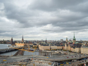 View of cityscape against cloudy sky