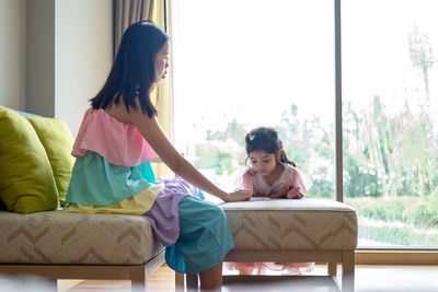 Mother assisting daughter in homework at home