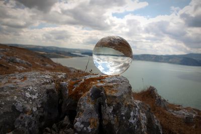 Scenic view of rock in sea against sky