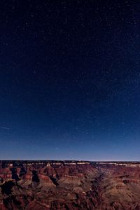 Scenic view of landscape against star field at night