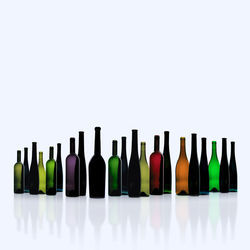 Row of wine bottles against white background