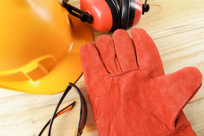 Close-up of gloves with hardhat and headphones on table