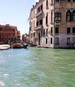 Canal amidst buildings against sky in city