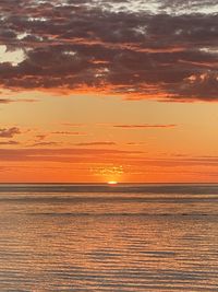 Scenic view of sea against dramatic sky during sunset