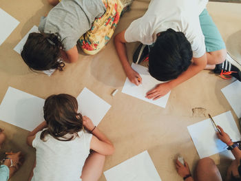 High angle view of children drawing on paper indoors