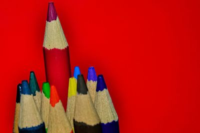 Close-up of colored pencils against red background