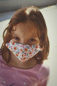Close-up portrait of cute girl wearing mask standing outdoors