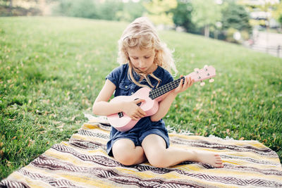 Full length of girl sitting on grass