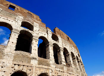 Low angle view of colosseum against clear blue sky
