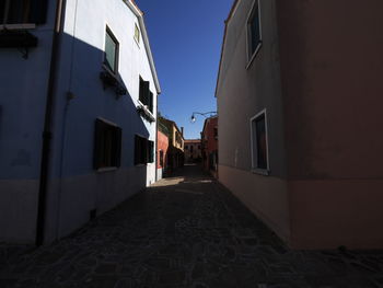 Empty alley amidst buildings in city