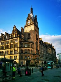 People on street against buildings in city