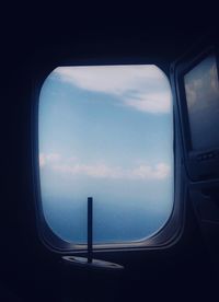 View of cloudy sky seen through airplane window