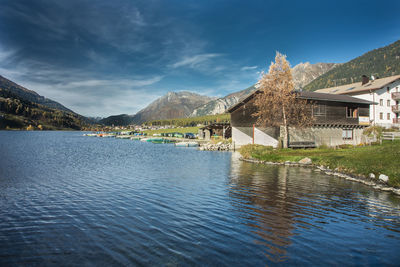 Scenic view of lake by buildings against sky