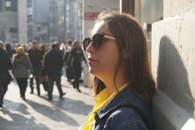 Portrait of young woman looking down in city